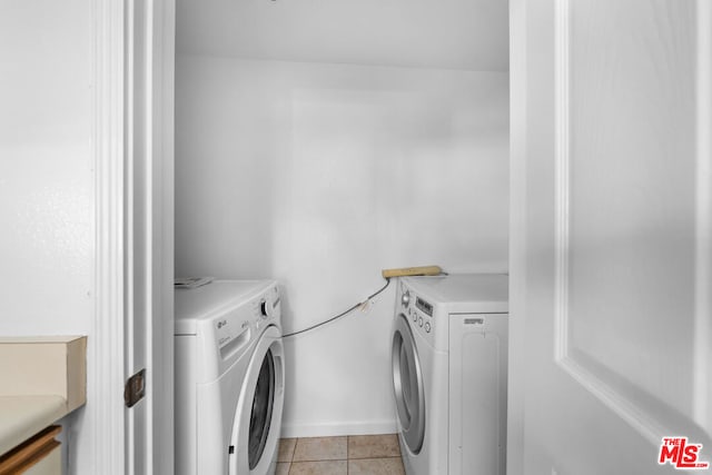 laundry room with washing machine and dryer and light tile patterned floors