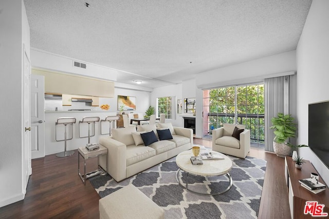 living room featuring dark wood-type flooring and a textured ceiling