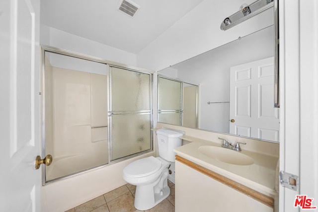 full bathroom with tile patterned floors, toilet, combined bath / shower with glass door, and vanity