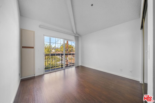 unfurnished room with lofted ceiling with beams, dark hardwood / wood-style floors, and a textured ceiling