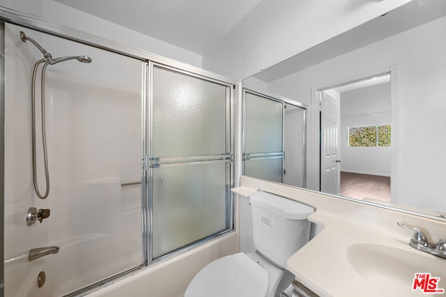 full bathroom with shower / bath combination with glass door, sink, wood-type flooring, and toilet