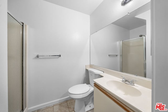 bathroom featuring tile patterned flooring, vanity, toilet, and an enclosed shower