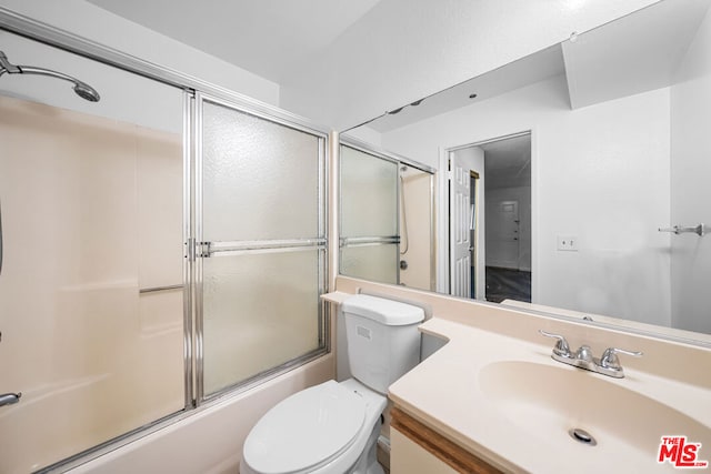 full bathroom featuring vanity, toilet, and bath / shower combo with glass door