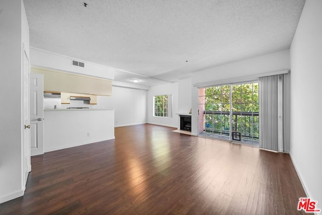 unfurnished living room featuring a textured ceiling and dark wood-type flooring