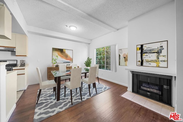 dining area featuring dark hardwood / wood-style flooring and a textured ceiling