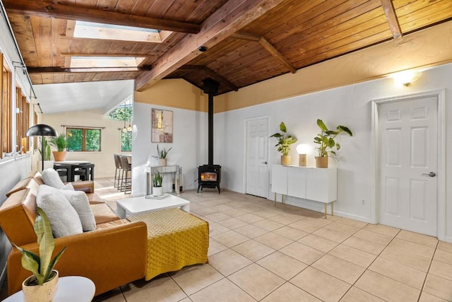 living room featuring wood ceiling, vaulted ceiling with skylight, light tile patterned flooring, and a wood stove