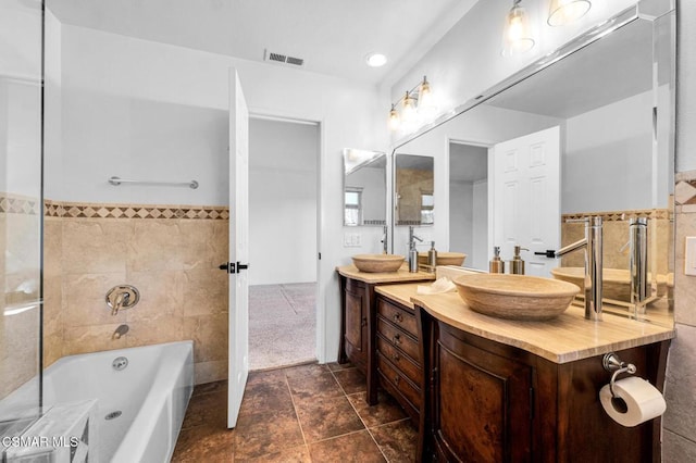 bathroom with tile patterned flooring, vanity, and tile walls