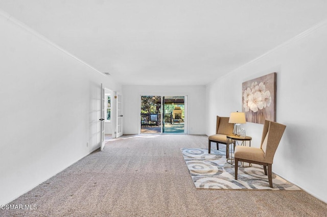 living area featuring carpet floors and ornamental molding