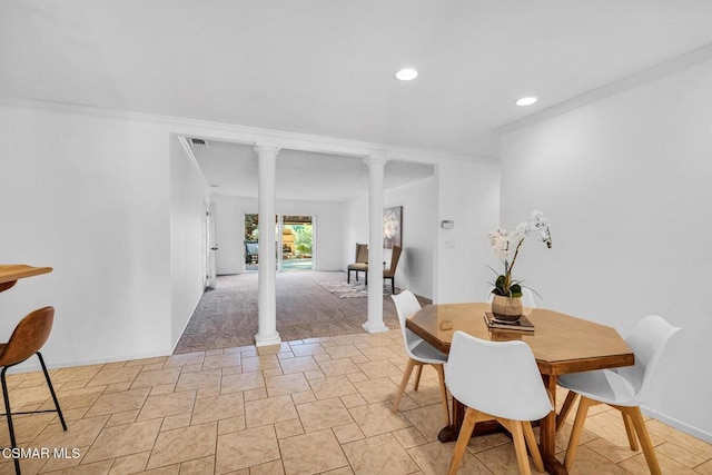 dining area featuring ornate columns and crown molding