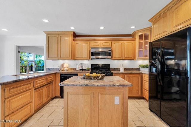 kitchen featuring sink, light stone counters, a kitchen island, and black appliances