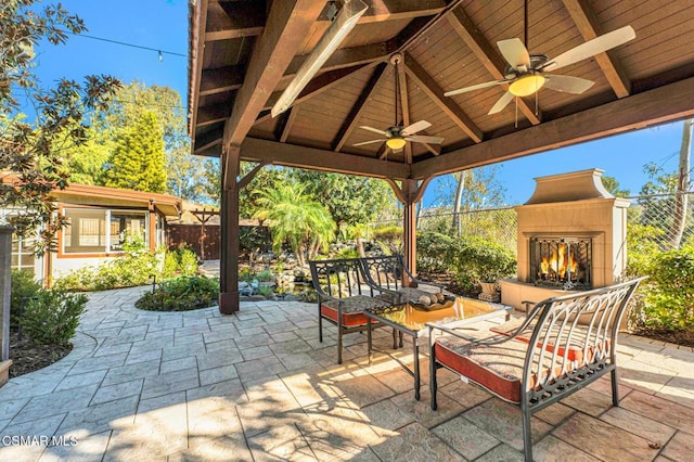 view of patio / terrace featuring an outdoor living space with a fireplace, a gazebo, and ceiling fan