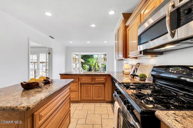 kitchen featuring light stone countertops, sink, french doors, and appliances with stainless steel finishes