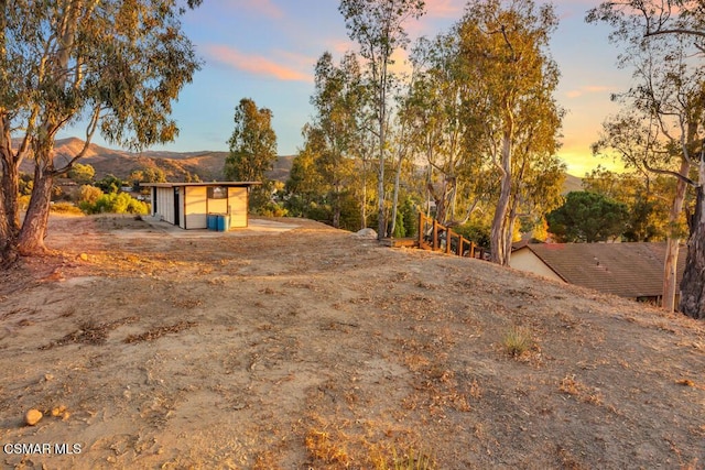 yard at dusk featuring a mountain view