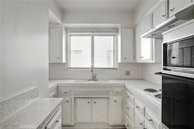 kitchen featuring tasteful backsplash, sink, and white cabinets