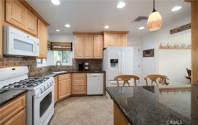 kitchen with light brown cabinetry, white appliances, sink, decorative light fixtures, and dark stone countertops