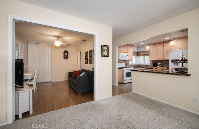 kitchen with light brown cabinets, white appliances, decorative backsplash, decorative light fixtures, and dark hardwood / wood-style flooring