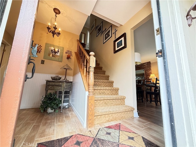 stairs featuring a chandelier and hardwood / wood-style floors