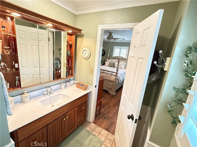 bathroom featuring vanity, hardwood / wood-style floors, ornamental molding, and ceiling fan