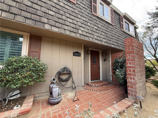 view of exterior entry with a patio area