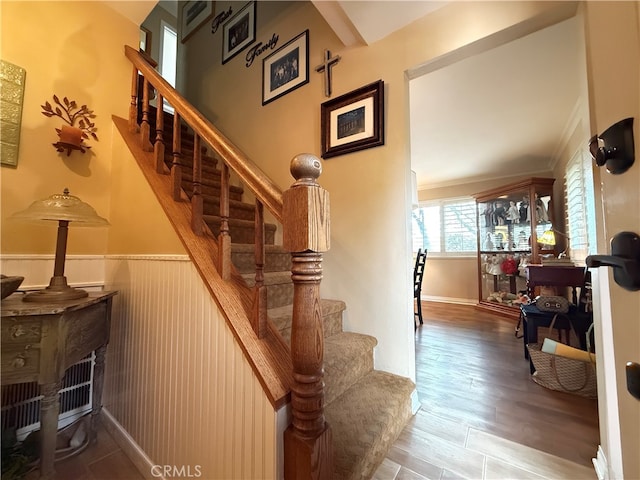 stairs featuring crown molding and wood-type flooring