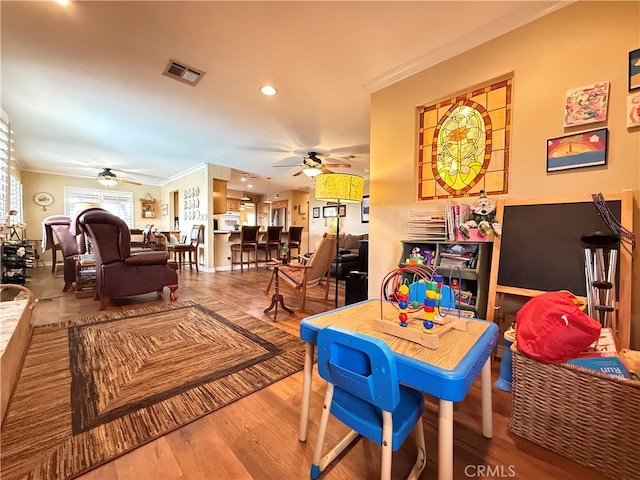 dining room featuring ornamental molding, wood-type flooring, and ceiling fan