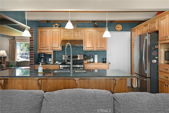 kitchen featuring tasteful backsplash, a breakfast bar, stainless steel appliances, and decorative light fixtures