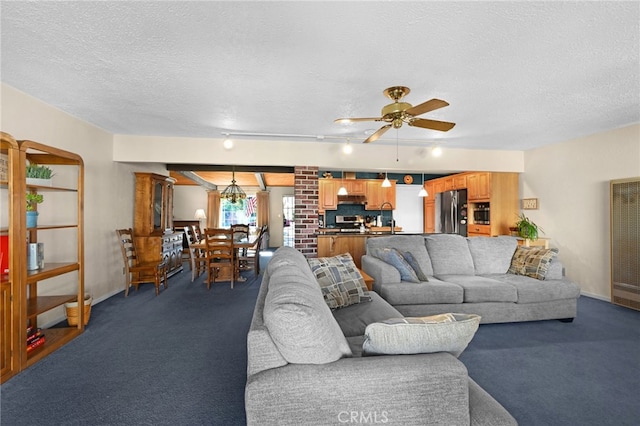 carpeted living room featuring ceiling fan, track lighting, and a textured ceiling