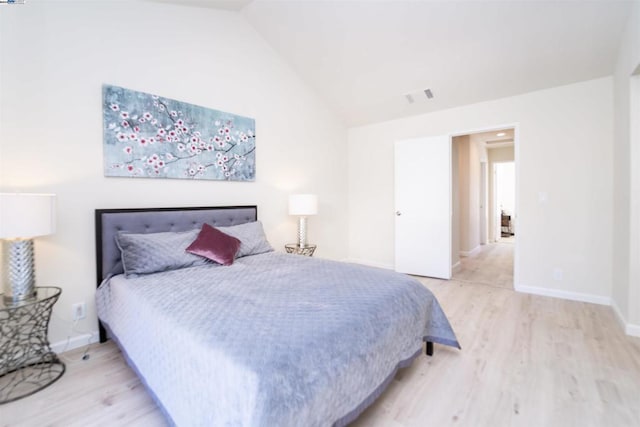 bedroom featuring light wood-type flooring and vaulted ceiling