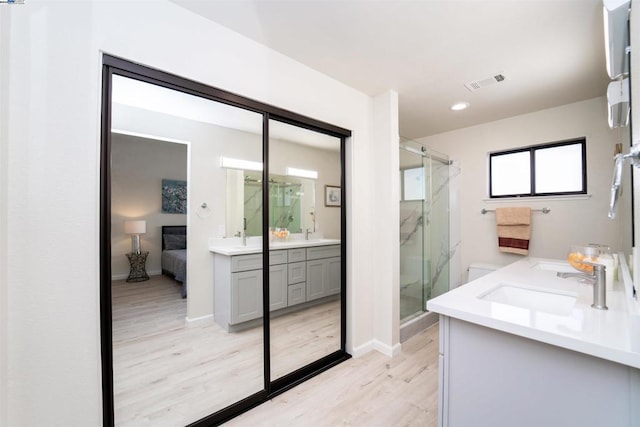 bathroom with a shower with door, vanity, and hardwood / wood-style flooring