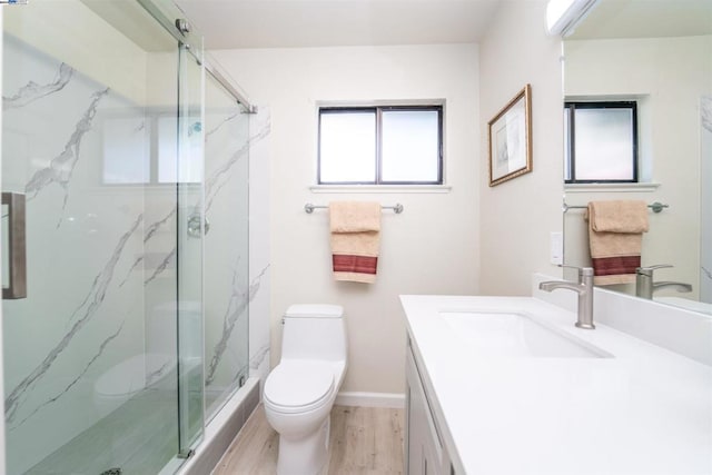 bathroom featuring hardwood / wood-style floors, vanity, toilet, and a shower with door