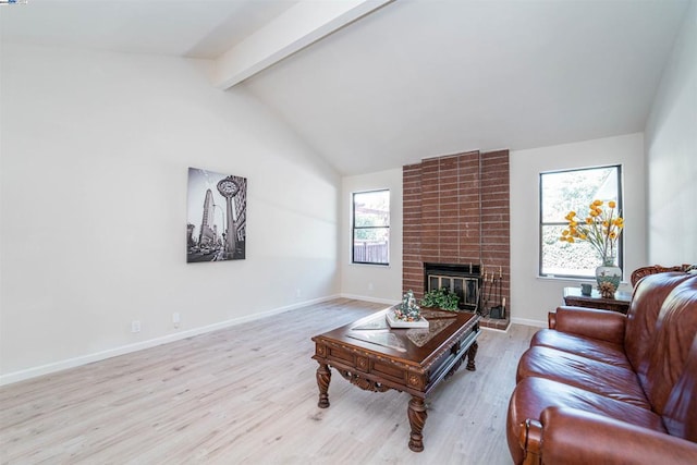 living room featuring light wood-type flooring, a brick fireplace, and a wealth of natural light