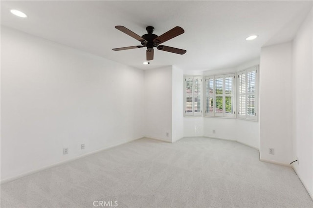 spare room featuring light carpet and ceiling fan