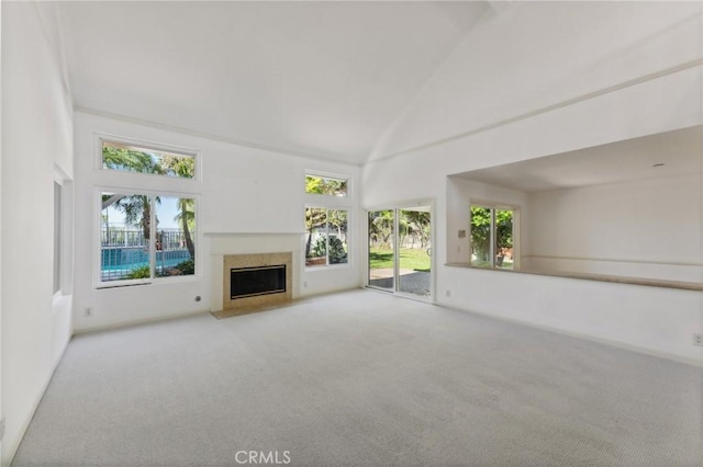 unfurnished living room with light carpet and high vaulted ceiling