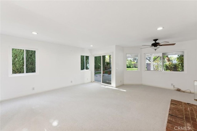 unfurnished living room featuring ceiling fan and carpet floors