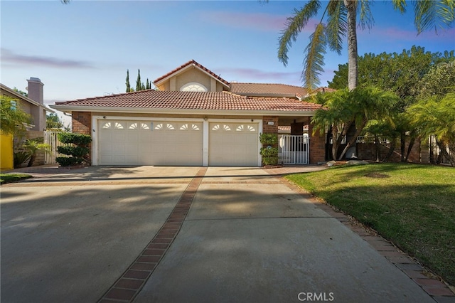 mediterranean / spanish home featuring a yard and a garage