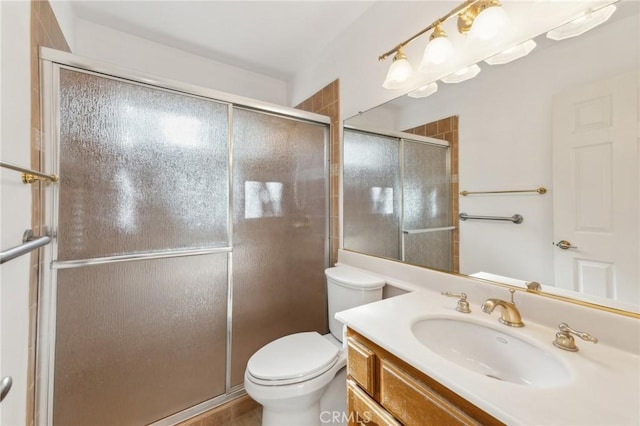 bathroom with an enclosed shower, vanity, and toilet