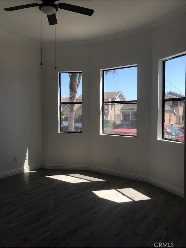 unfurnished room with crown molding, ceiling fan, and dark hardwood / wood-style flooring