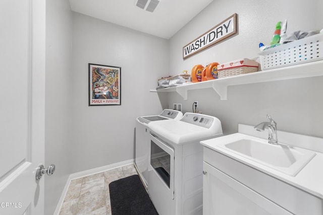 laundry room with washer and dryer, cabinets, and sink