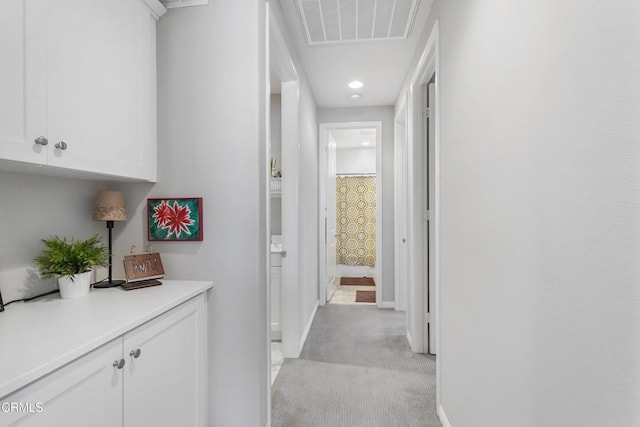 hallway featuring light colored carpet