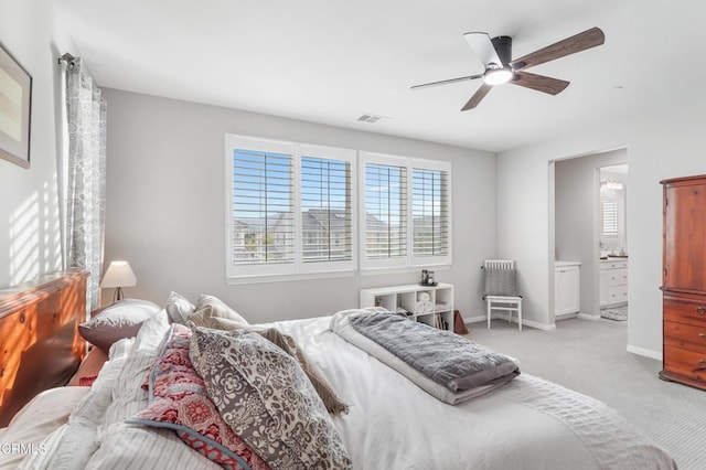 bedroom featuring ensuite bath, ceiling fan, and light carpet