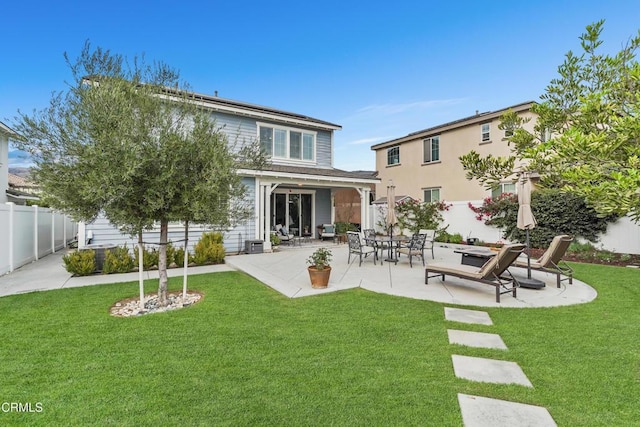 back of house with a patio and a lawn