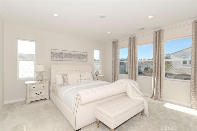 bedroom featuring multiple windows and light colored carpet