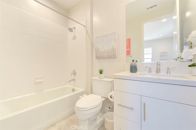 full bathroom featuring vanity, tiled shower / bath combo, and toilet