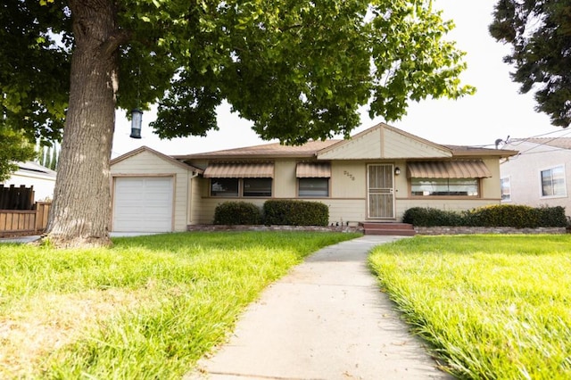 ranch-style house featuring a front yard and a garage