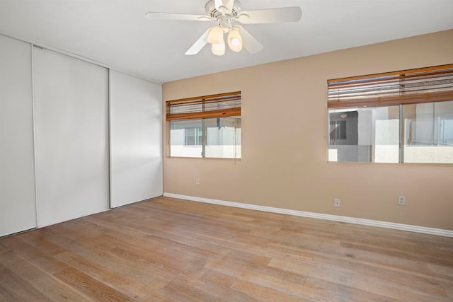 unfurnished bedroom featuring light hardwood / wood-style floors, a closet, and ceiling fan