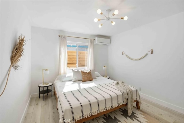 62044 Valley View Cir, Joshua Tree, CA 92252 - bedroom featuring an AC wall unit, wood finished floors, and a chandelier