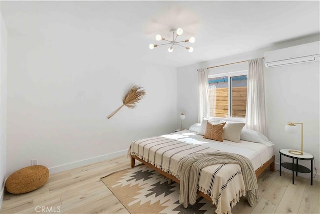 62044 Valley View Cir, Joshua Tree, CA 92252 - bedroom with an AC wall unit, wood-type flooring, and a chandelier