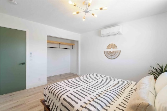 62044 Valley View Cir, Joshua Tree, CA 92252 - bedroom with a wall mounted air conditioner, a chandelier, light wood-style floors, and a closet