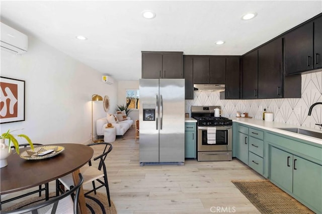62044 Valley View Cir, Joshua Tree, CA 92252 - kitchen featuring stainless steel appliances, under cabinet range hood, an AC wall unit, recessed lighting, and light wood-type flooring