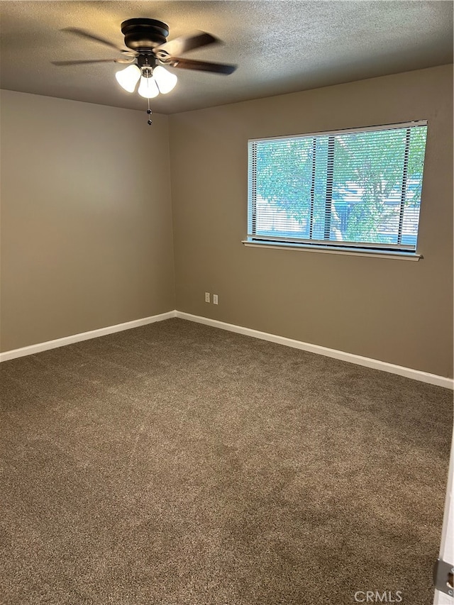 carpeted spare room featuring a textured ceiling and ceiling fan